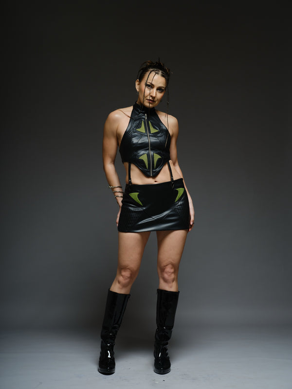 Black leather crop top and mini skirt with neon green inserts, black mesh overlays, stitched panels and triangular metal hardware