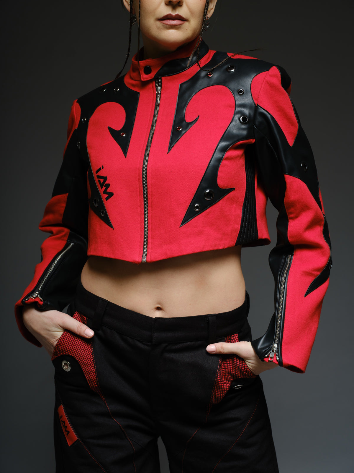 Red denim jacket with pointed black leather patches, mixed-size metal hardware, front zipper and sleeve zippers