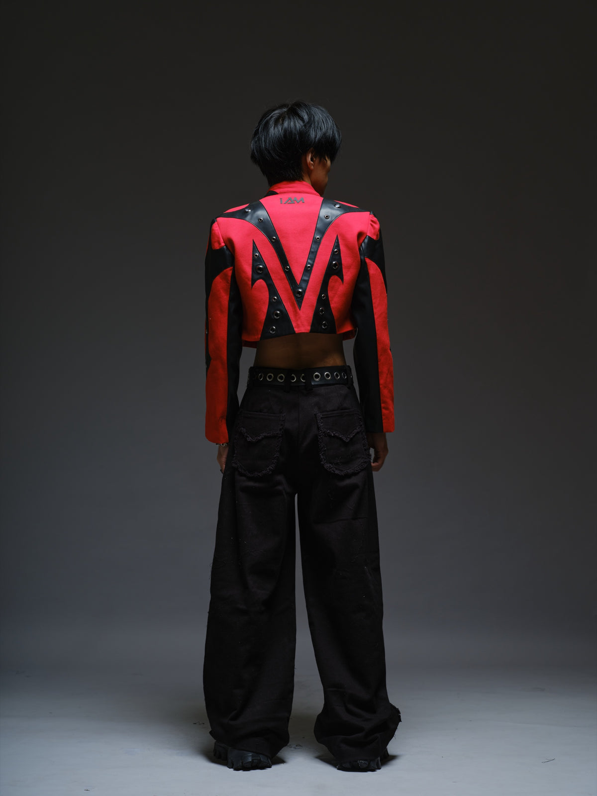 Red denim jacket with pointed black leather patches, mixed-size metal hardware, front zipper and sleeve zippers