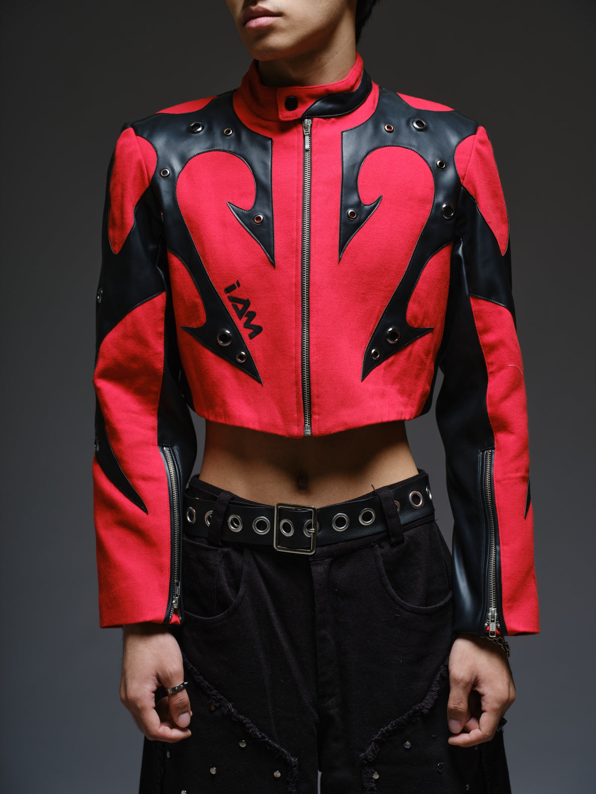 Red denim jacket with pointed black leather patches, mixed-size metal hardware, front zipper and sleeve zippers