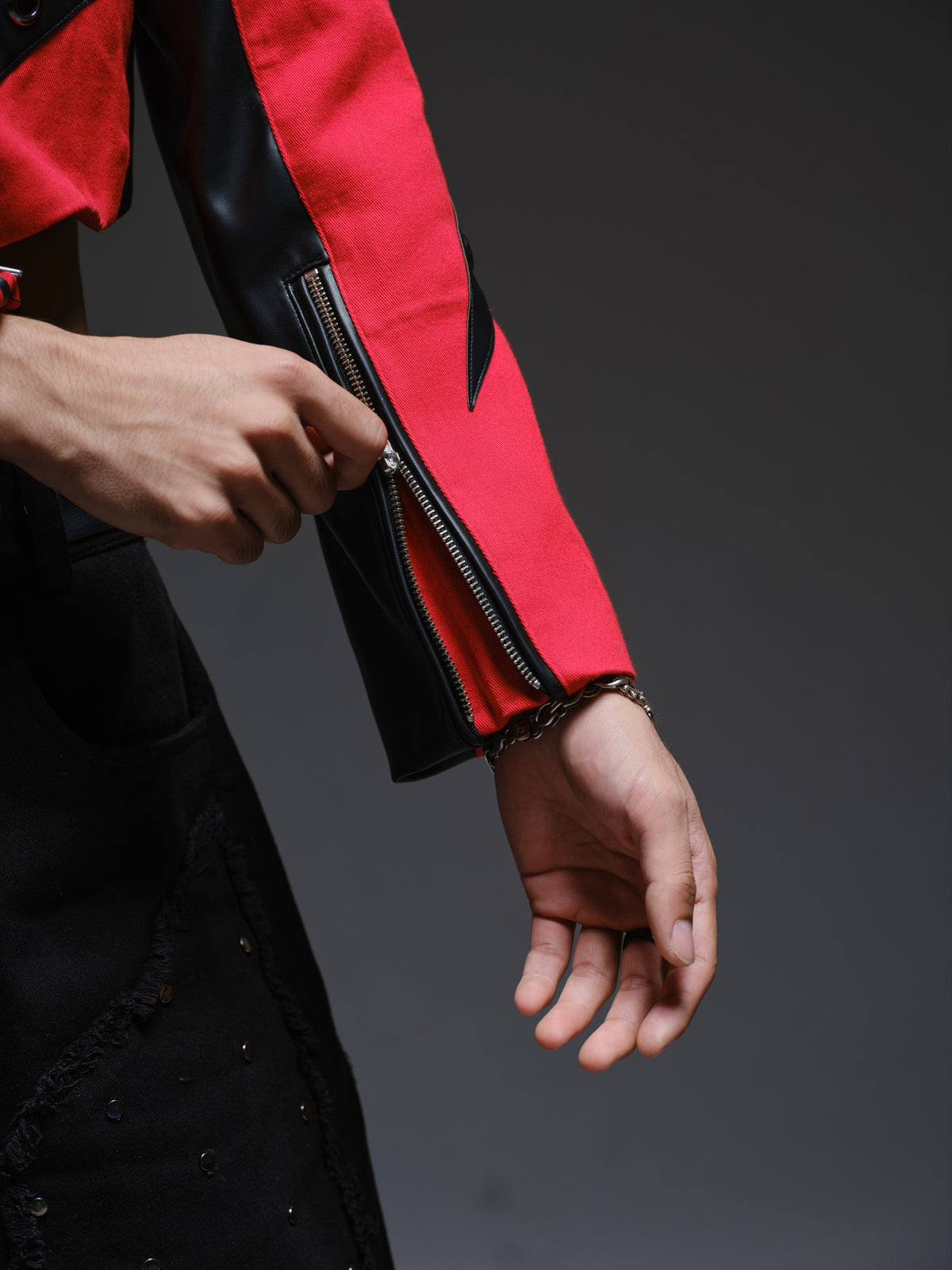 Red denim jacket with pointed black leather patches, mixed-size metal hardware, front zipper and sleeve zippers