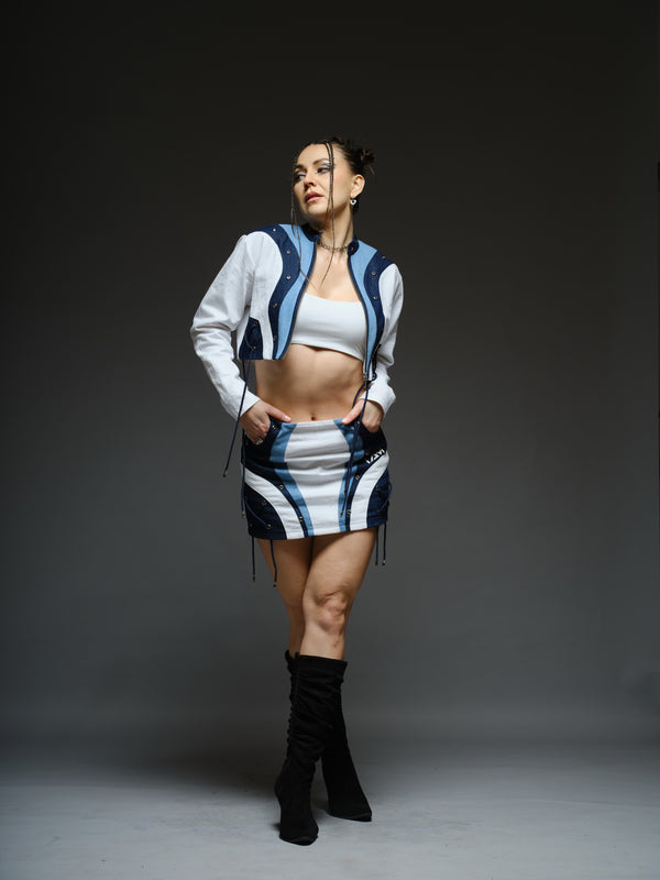 White and blue panelled denim cropped jacket and A-line skirt with metal rivets and criss-cross cord detailing