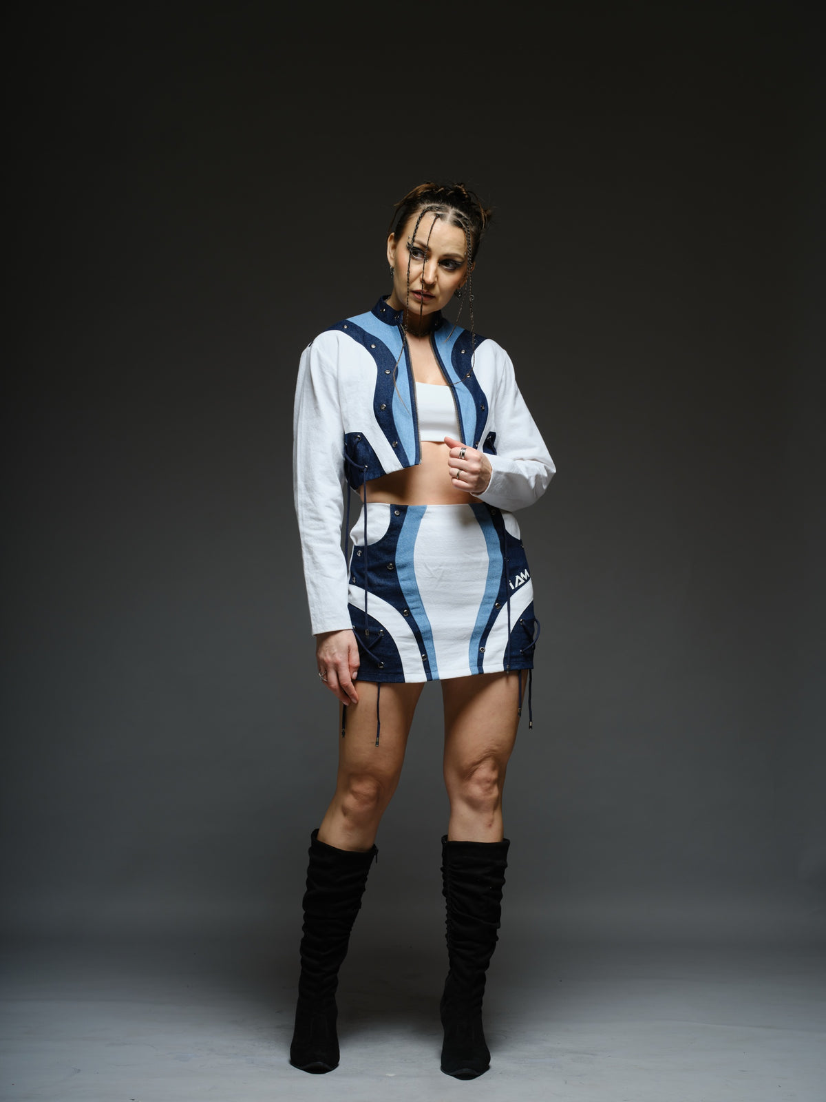 White and blue panelled denim cropped jacket and A-line skirt with metal rivets and criss-cross cord detailing