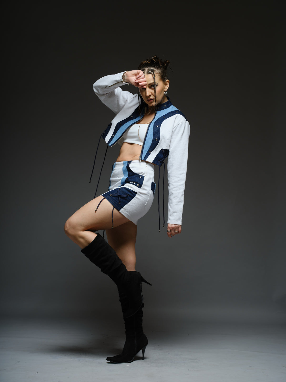 White and blue panelled denim cropped jacket and A-line skirt with metal rivets and criss-cross cord detailing