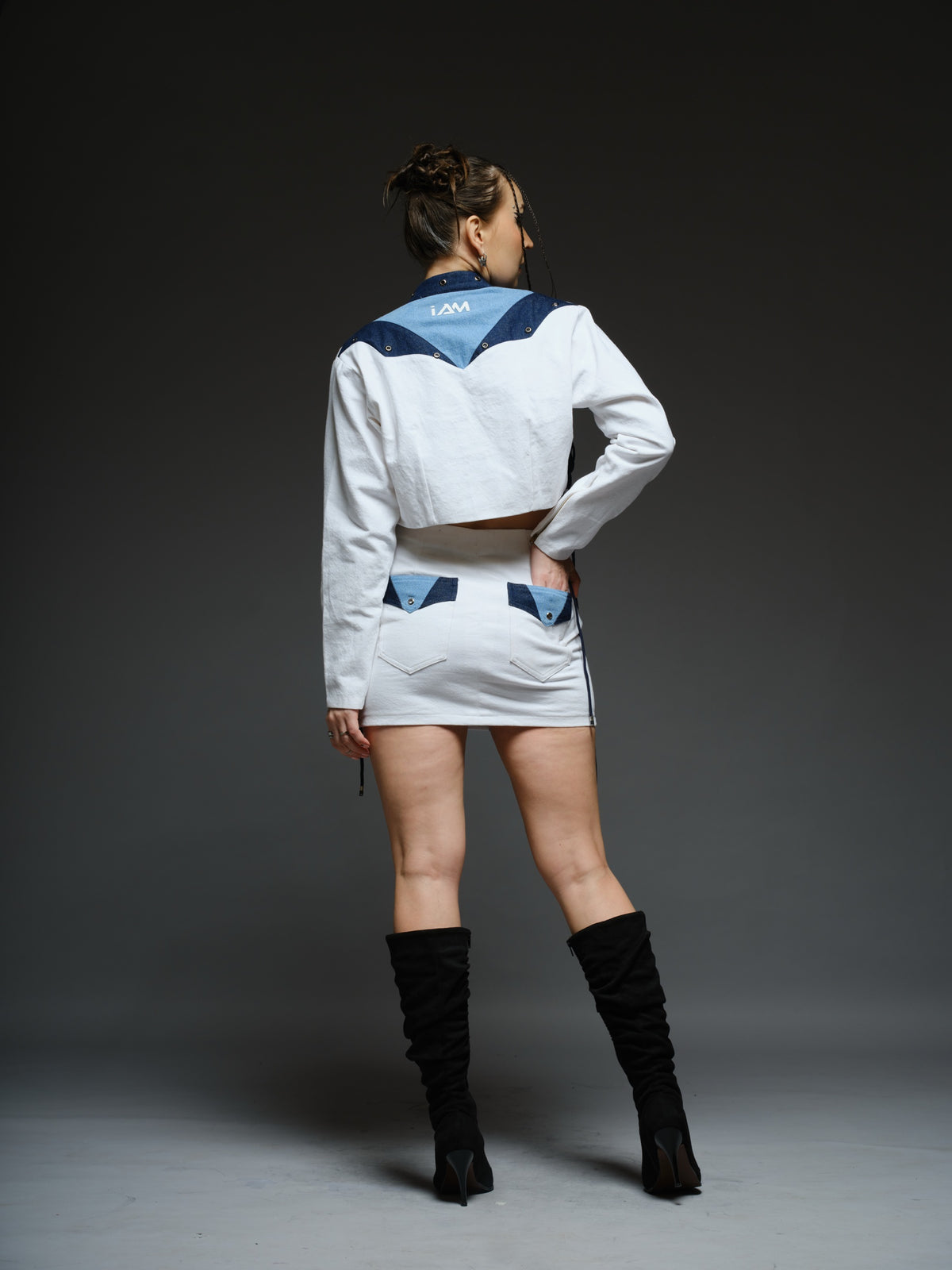 White and blue panelled denim cropped jacket and A-line skirt with metal rivets and criss-cross cord detailing