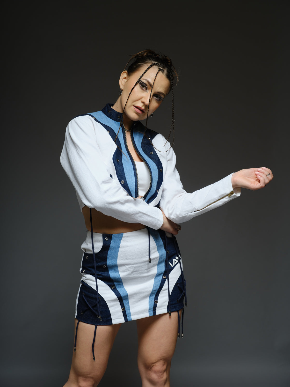 White and blue panelled denim cropped jacket and A-line skirt with metal rivets and criss-cross cord detailing