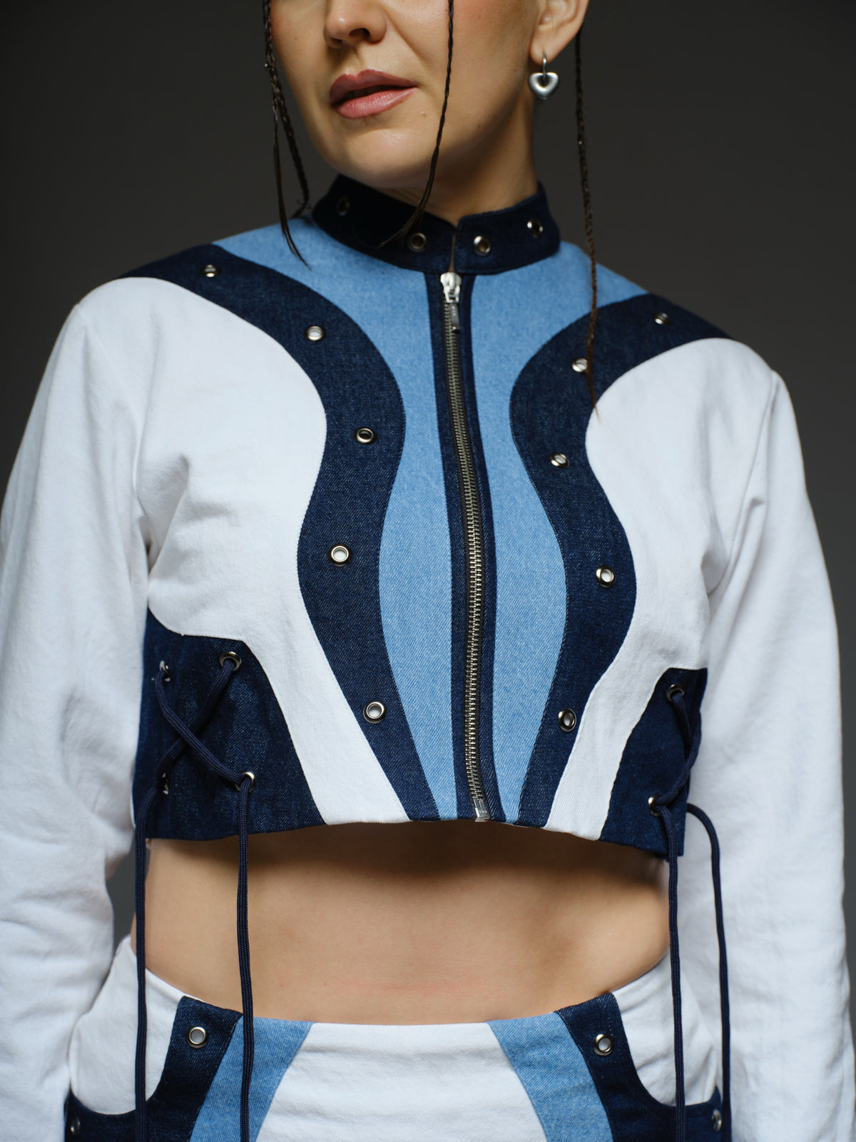 White and blue panelled denim cropped jacket and A-line skirt with metal rivets and criss-cross cord detailing