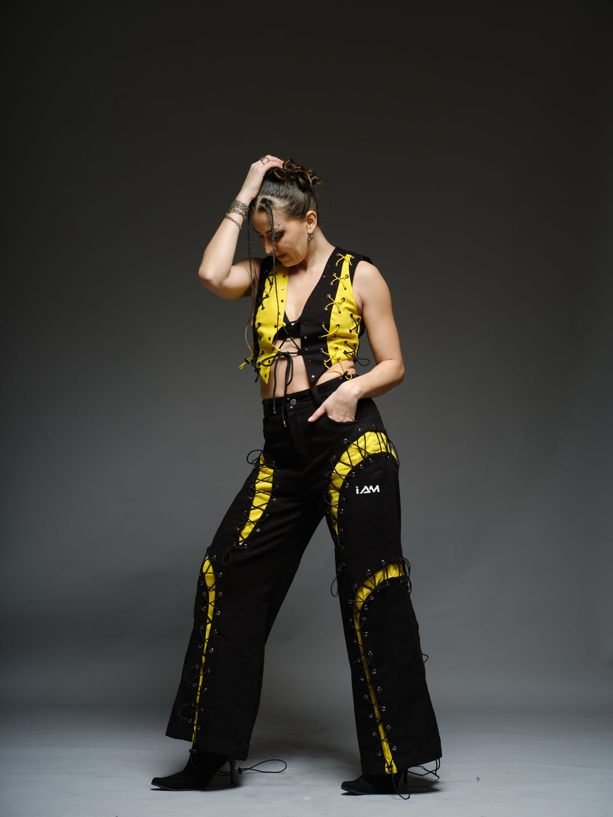 Yellow and black denim cropped vest and baggy trousers with criss-cross lacing, metal hardware and a studded waistband