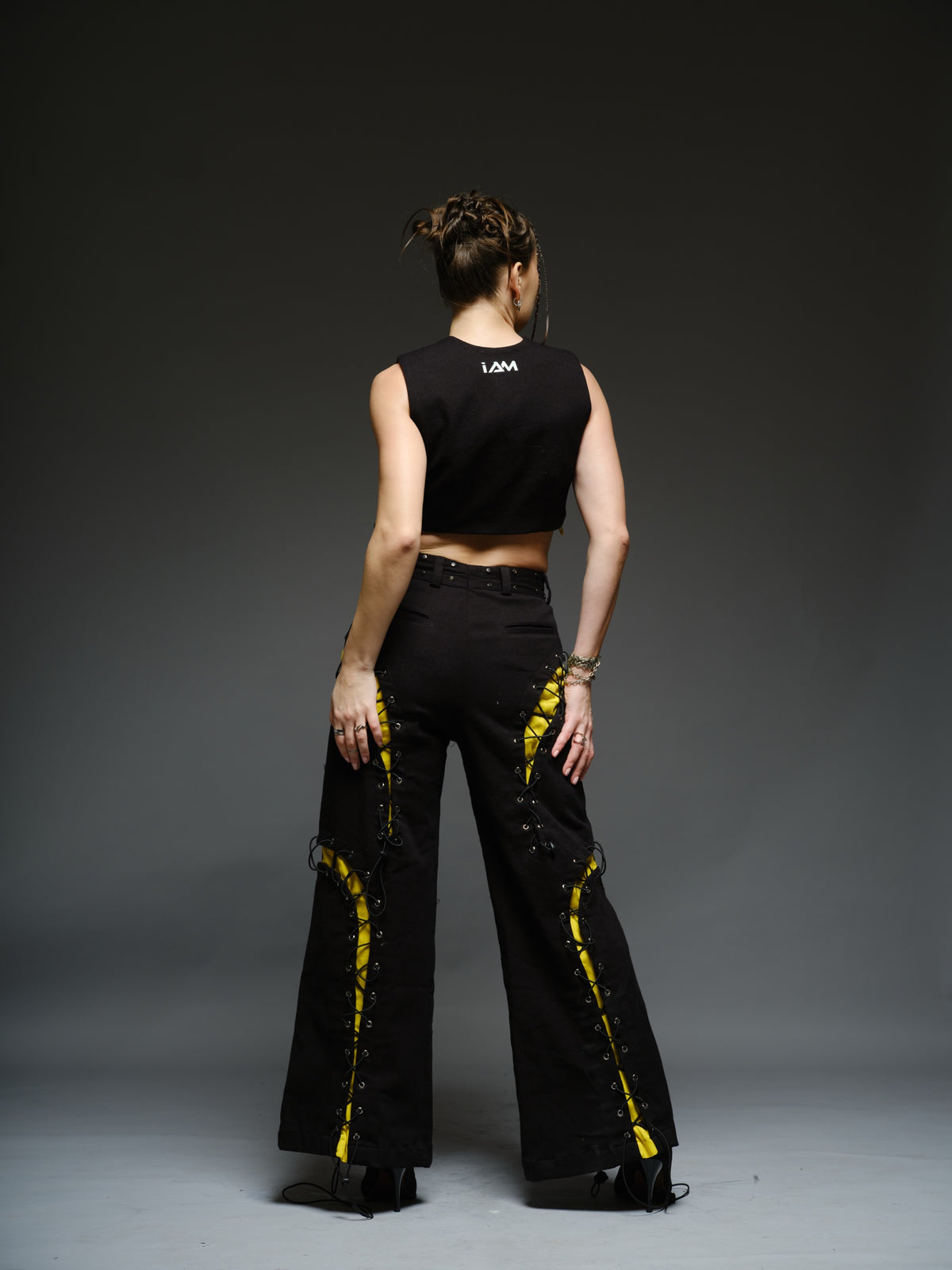 Yellow and black denim cropped vest and baggy trousers with criss-cross lacing, metal hardware and a studded waistband