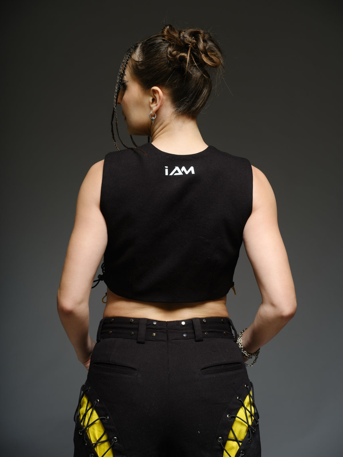 Yellow and black denim cropped vest and baggy trousers with criss-cross lacing, metal hardware and a studded waistband