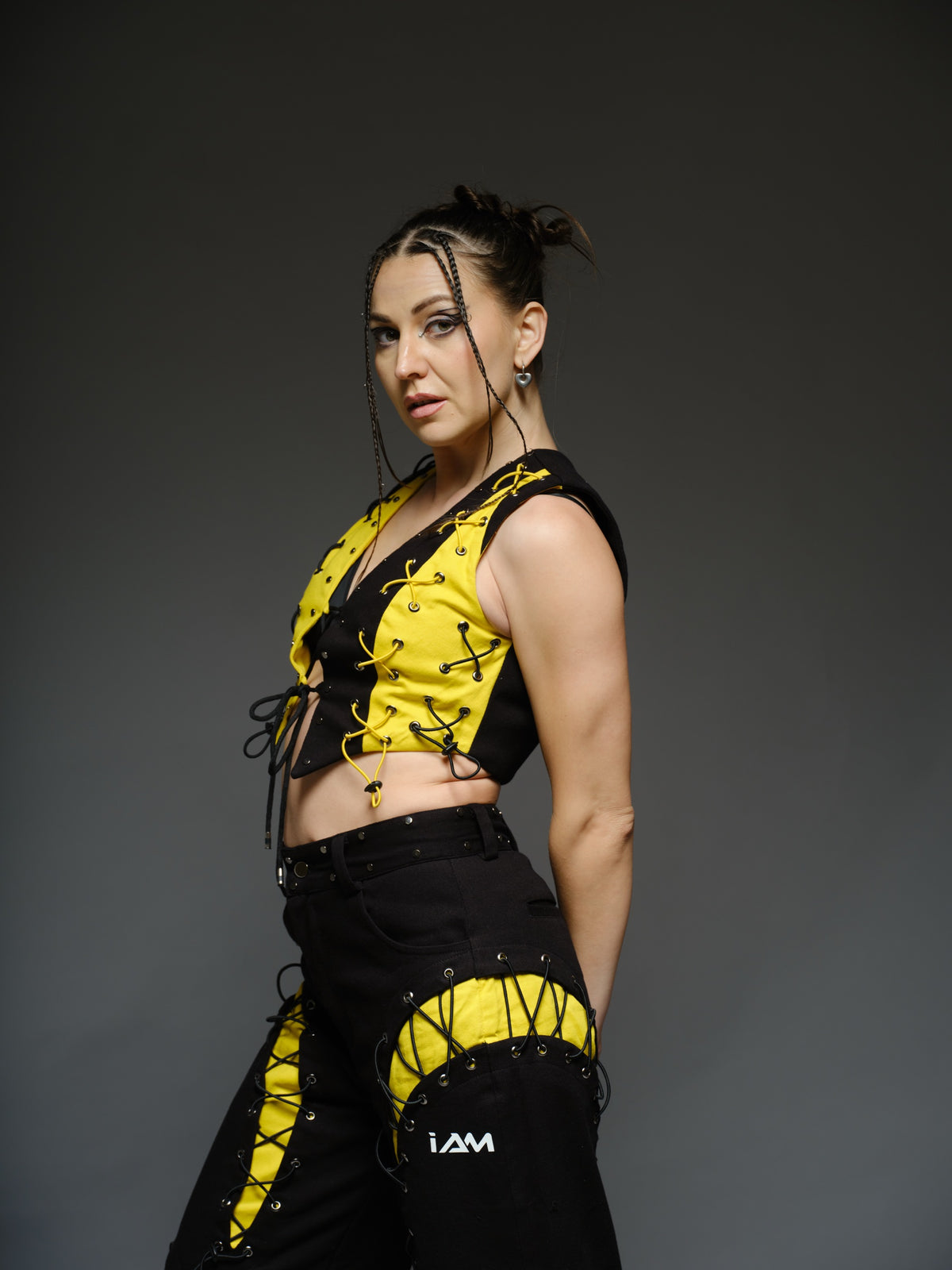 Yellow and black denim cropped vest and baggy trousers with criss-cross lacing, metal hardware and a studded waistband