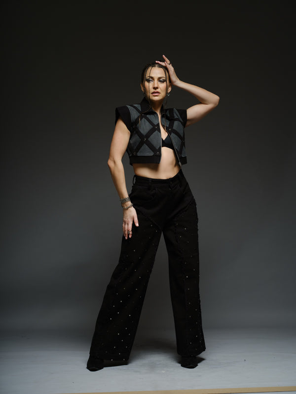 Black sleeveless denim jacket with a grey net overlay, diamond-pattern black bands, metal eyelets and a front zipper
