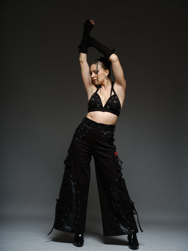 Black padded halter bralette with metallic detailing, paired with baggy denim pants with leather inset patches and four side pockets