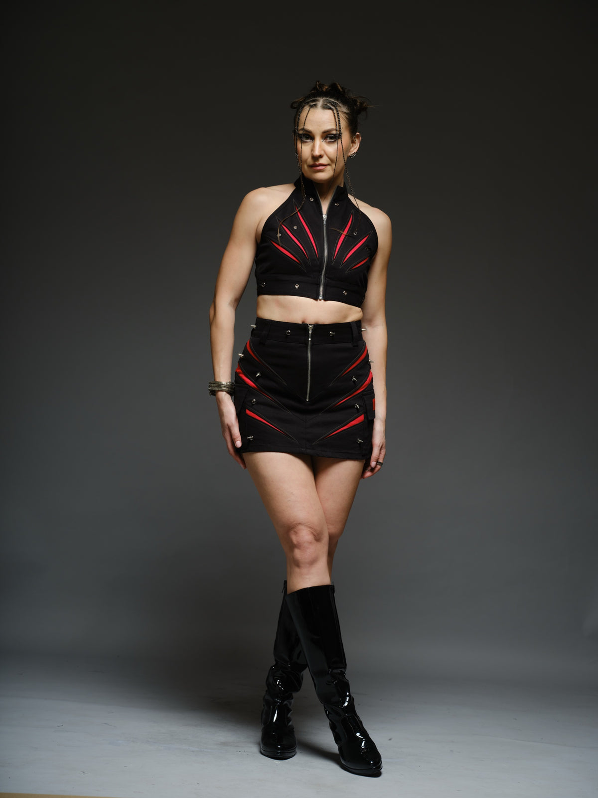 Black denim halter crop top and fitted mini skirt with red claw-shaped inserts, silver-tone rivets and exposed front zippers.