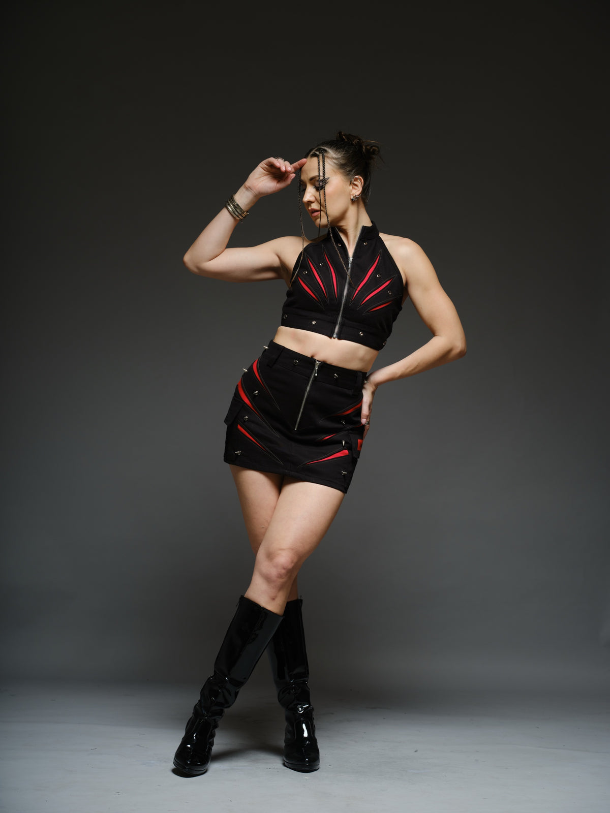 Black denim halter crop top and fitted mini skirt with red claw-shaped inserts, silver-tone rivets and exposed front zippers.