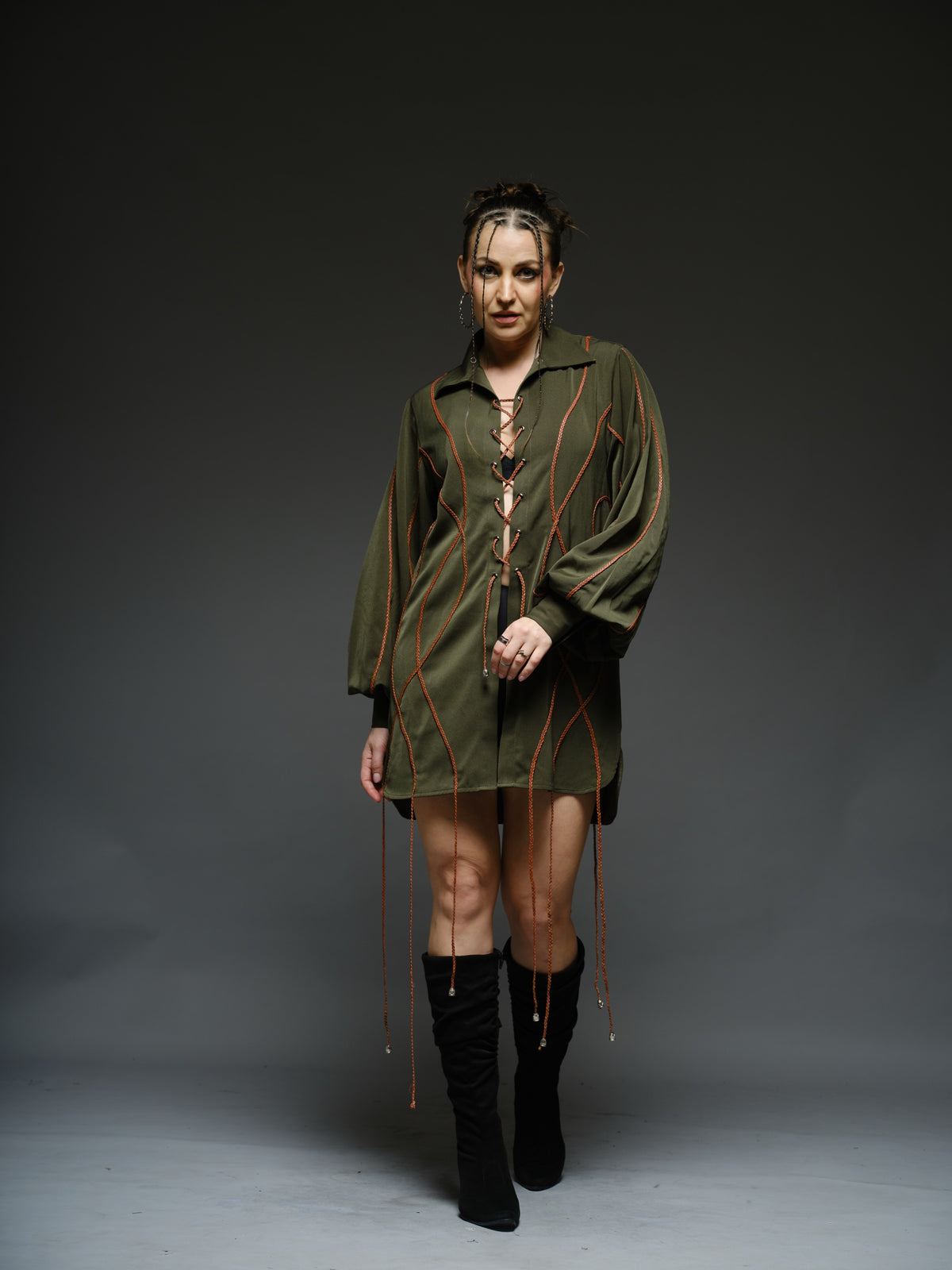 Olive green shirt dress with balloon sleeves, front lacing and contrast braided cords extending below the hem