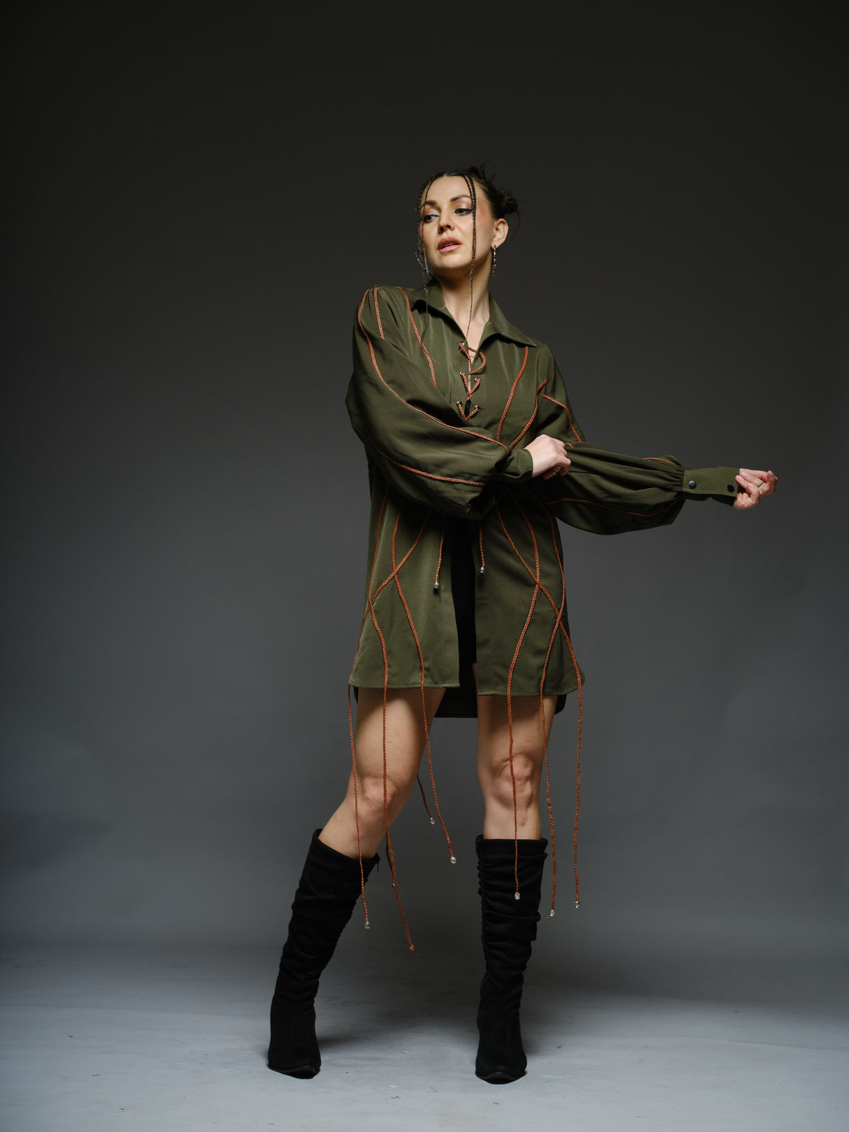 Olive green shirt dress with balloon sleeves, front lacing and contrast braided cords extending below the hem