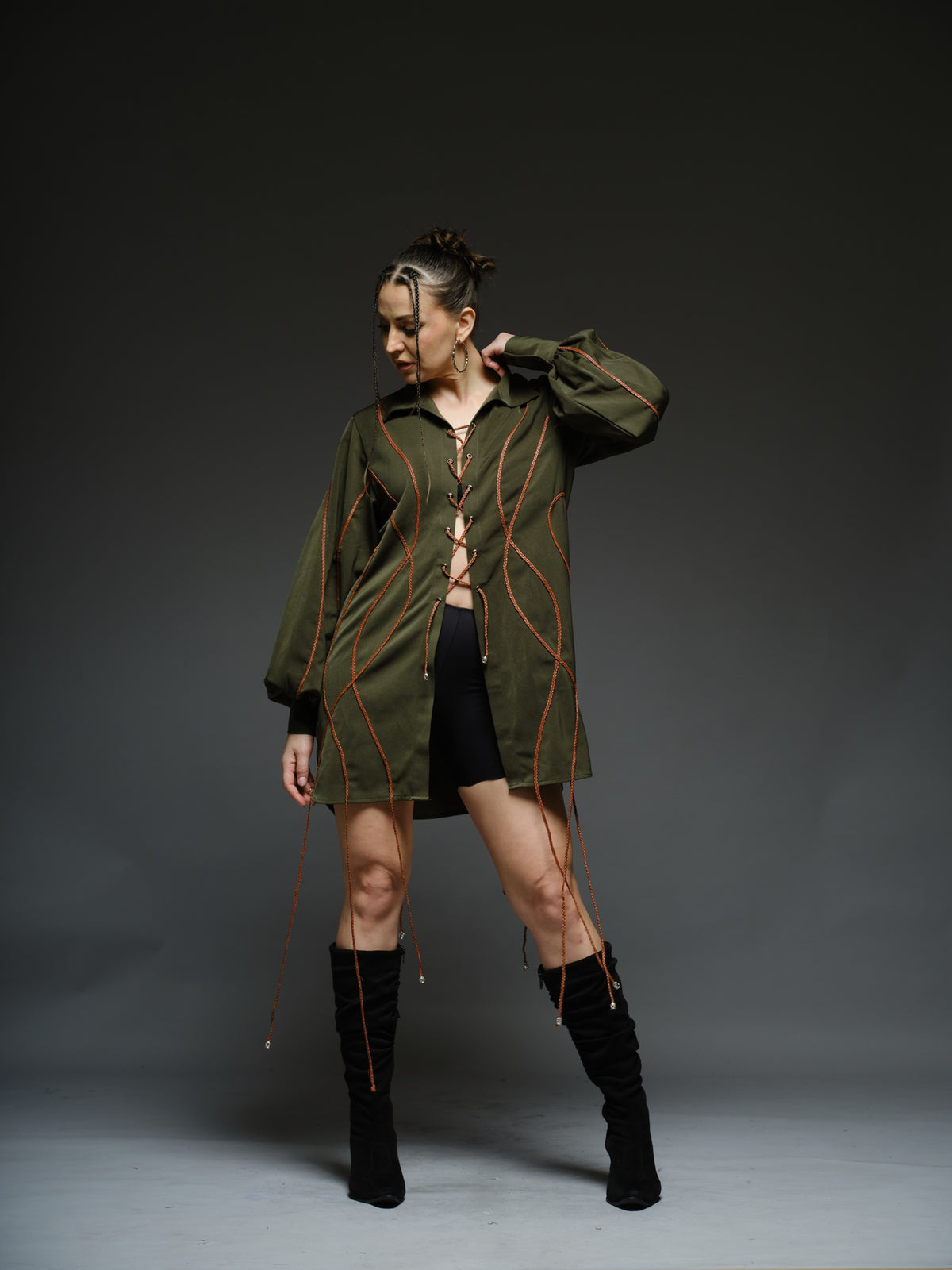 Olive green shirt dress with balloon sleeves, front lacing and contrast braided cords extending below the hem