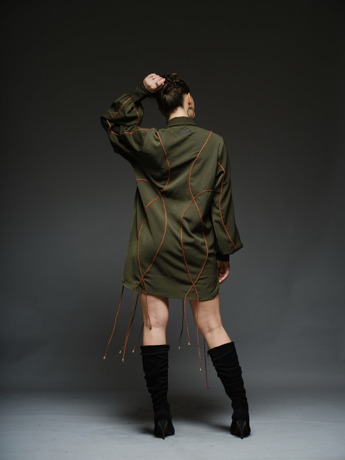 Olive green shirt dress with balloon sleeves, front lacing and contrast braided cords extending below the hem