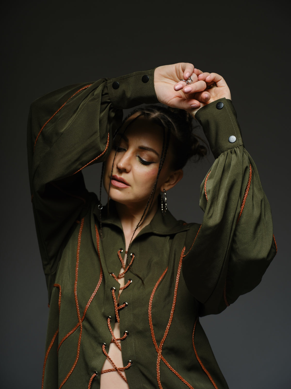 Olive green shirt dress with balloon sleeves, front lacing and contrast braided cords extending below the hem