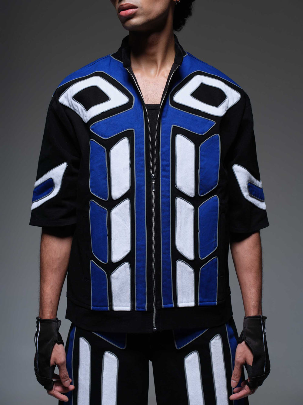 Black "Night Shifter Jacket" with prominent white embroidered logo on the chest and back, shown on a mannequin.
