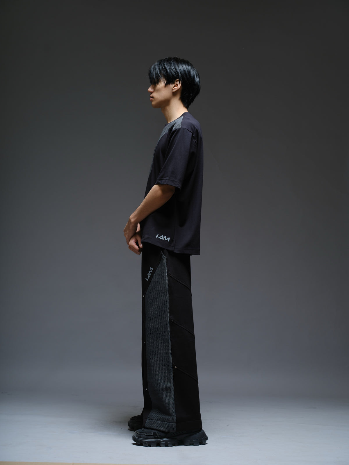 Black Roma knit short-sleeve tee with curved grey net panels across the shoulders and front