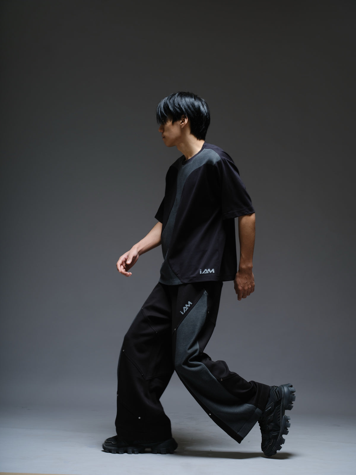 Black Roma knit short-sleeve tee with curved grey net panels across the shoulders and front