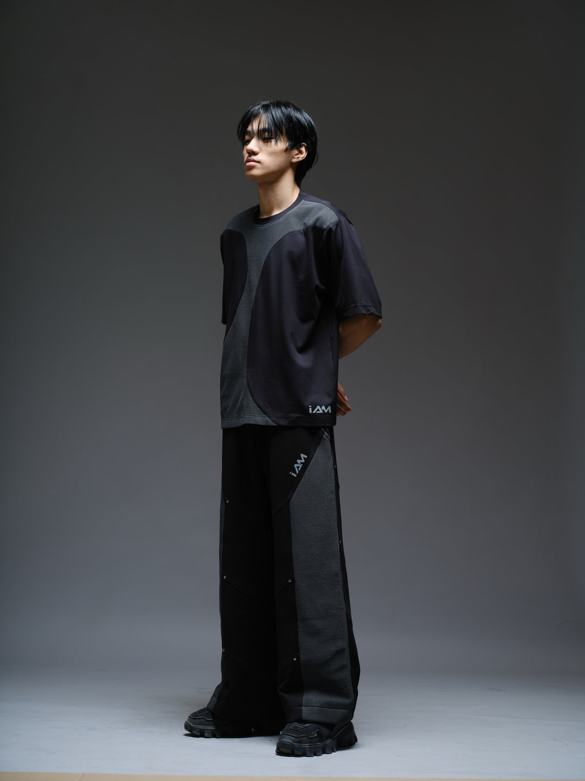 Black Roma knit short-sleeve tee with curved grey net panels across the shoulders and front