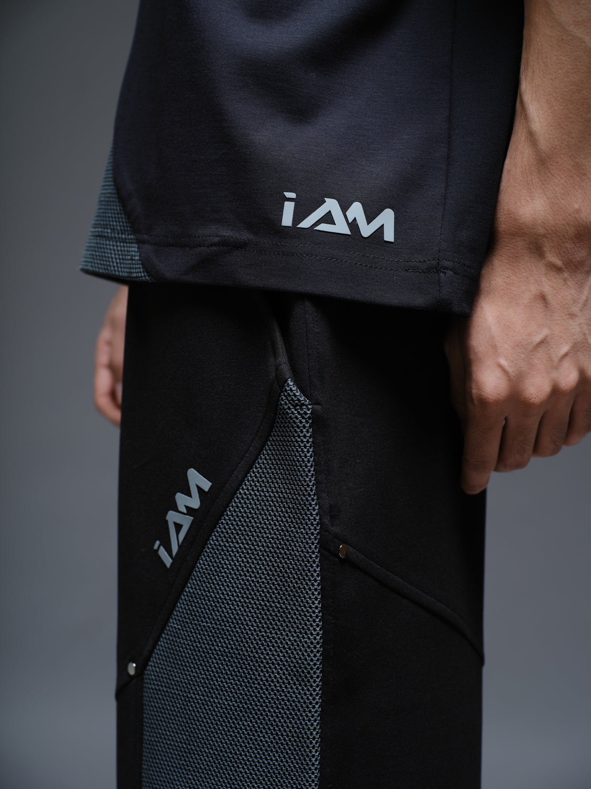 Black Roma knit short-sleeve tee with curved grey net panels across the shoulders and front