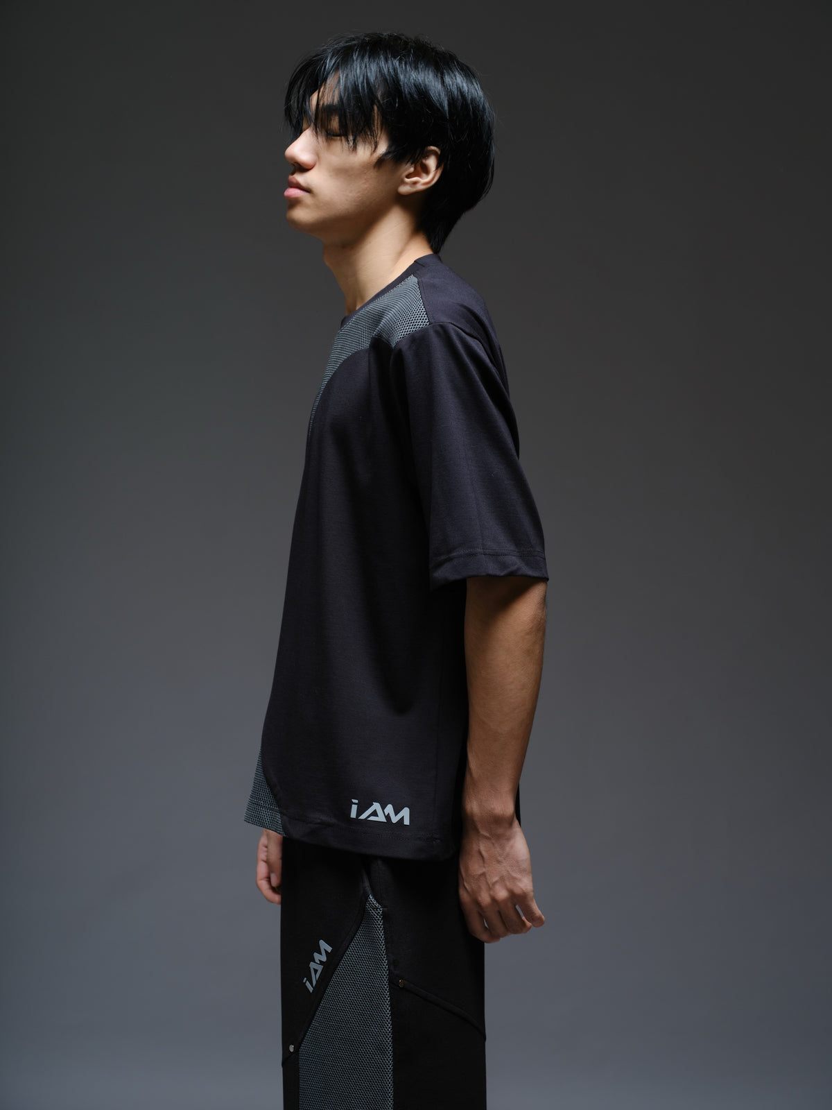 Black Roma knit short-sleeve tee with curved grey net panels across the shoulders and front