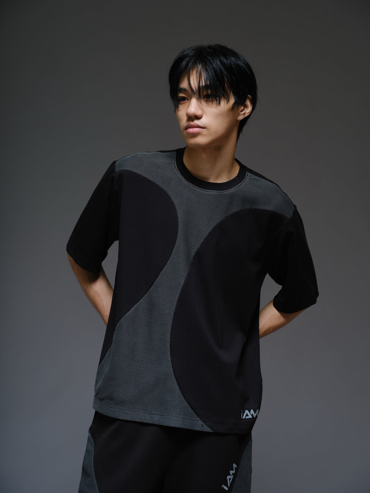 Black Roma knit short-sleeve tee with curved grey net panels across the shoulders and front