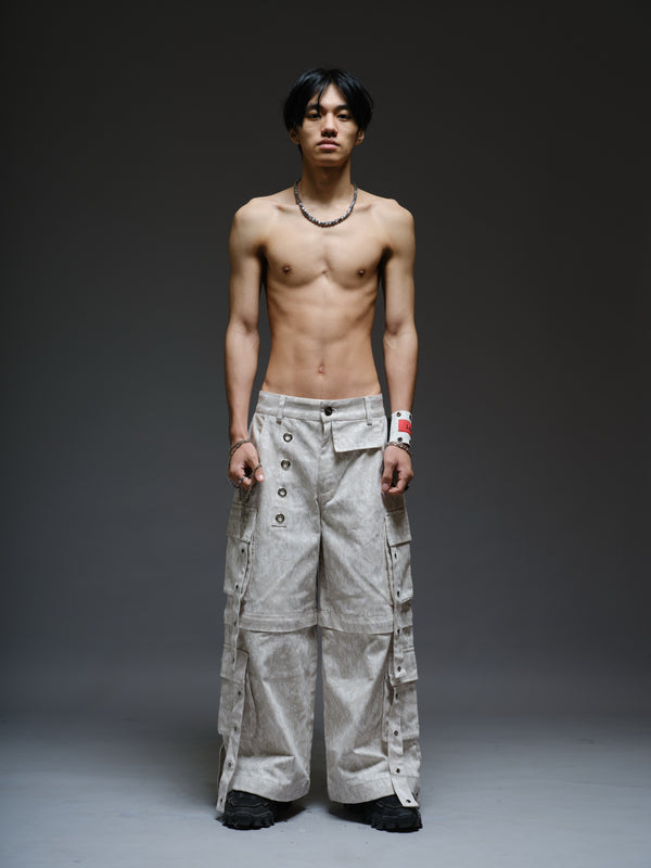 Printed camo denim cargo pants with detachable lower legs, oversized flap pockets and hanging straps