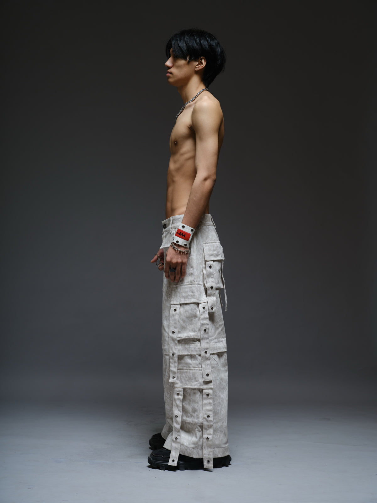 Printed camo denim cargo pants with detachable lower legs, oversized flap pockets and hanging straps