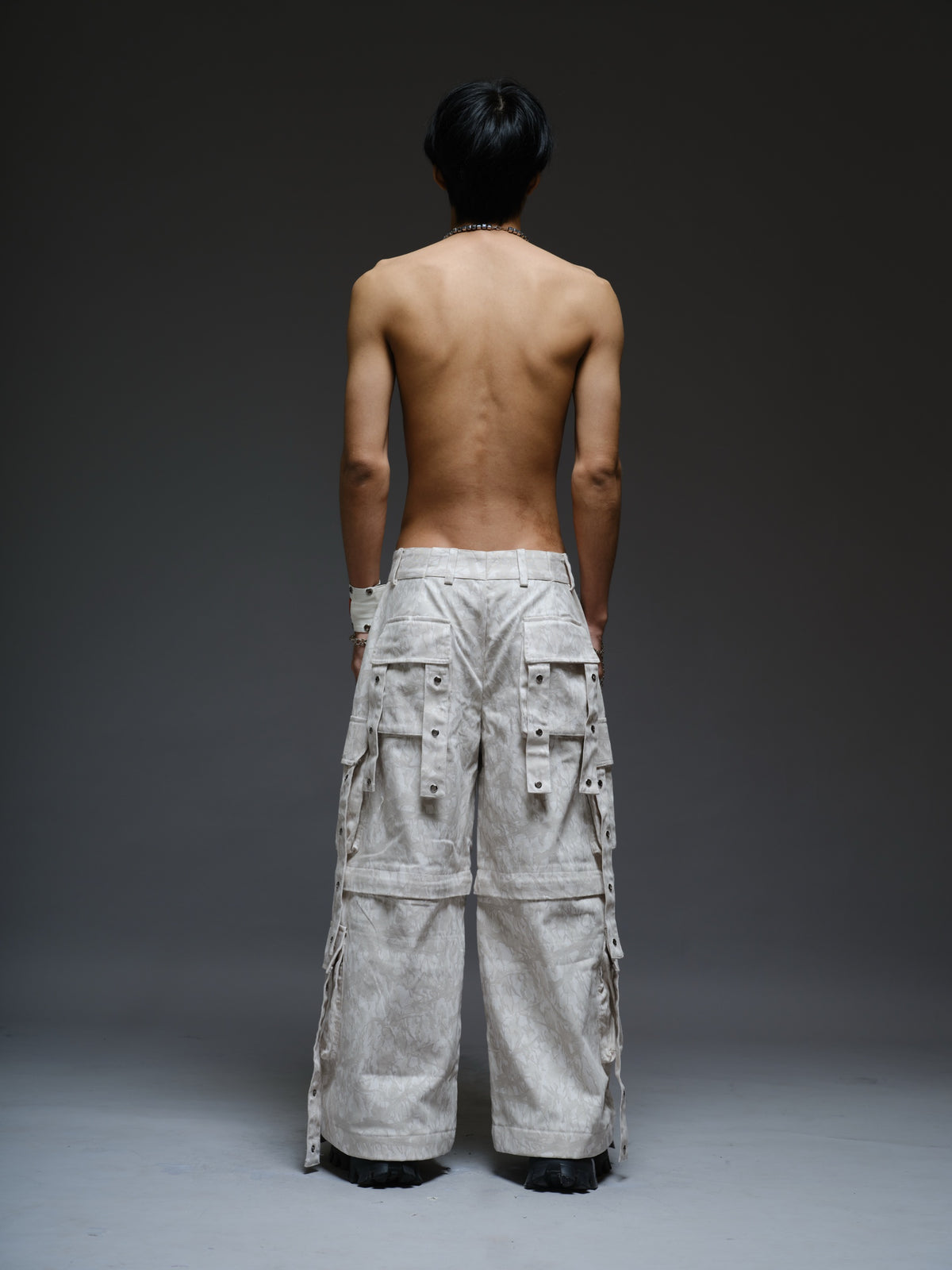 Printed camo denim cargo pants with detachable lower legs, oversized flap pockets and hanging straps