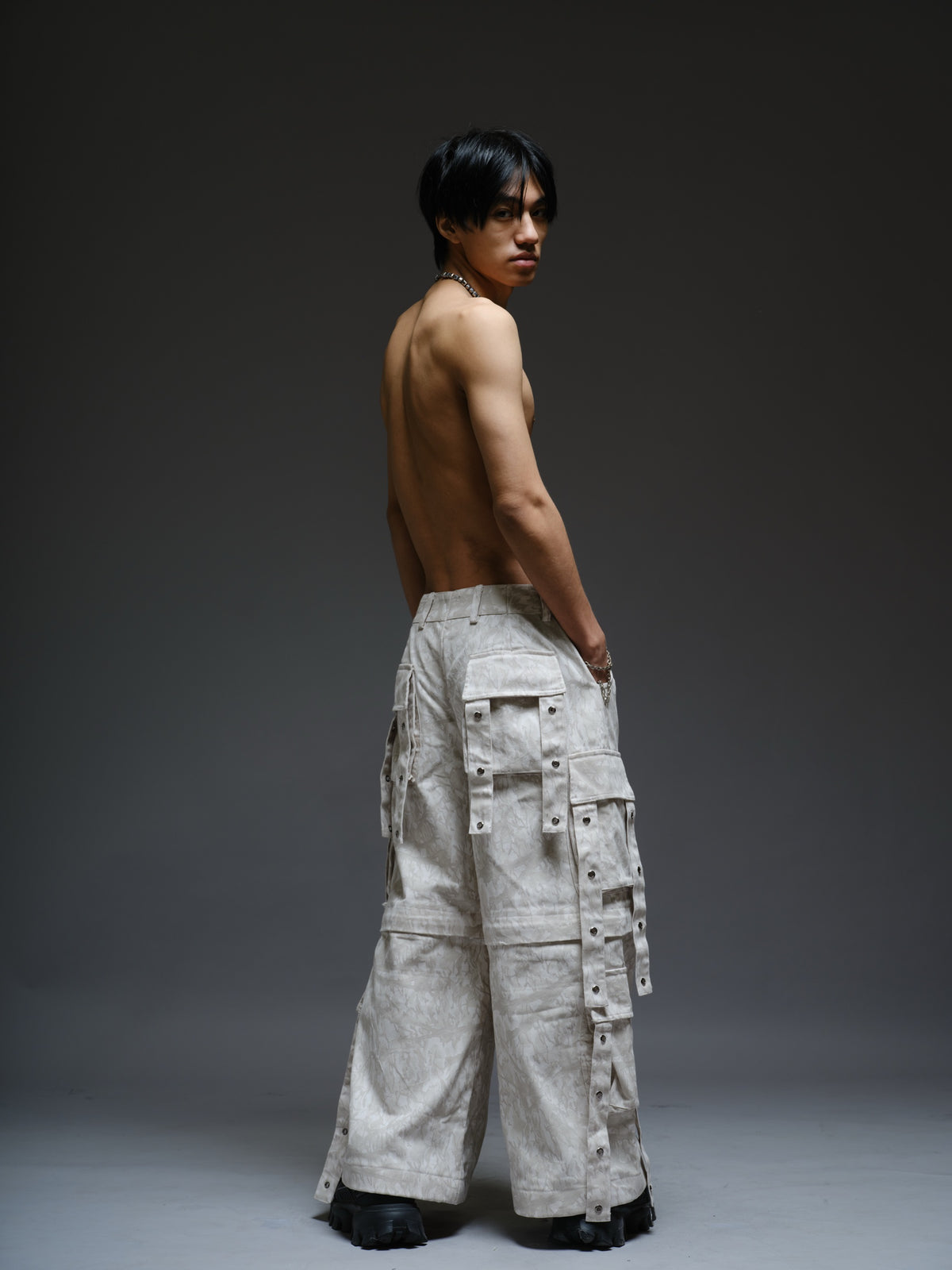 Printed camo denim cargo pants with detachable lower legs, oversized flap pockets and hanging straps