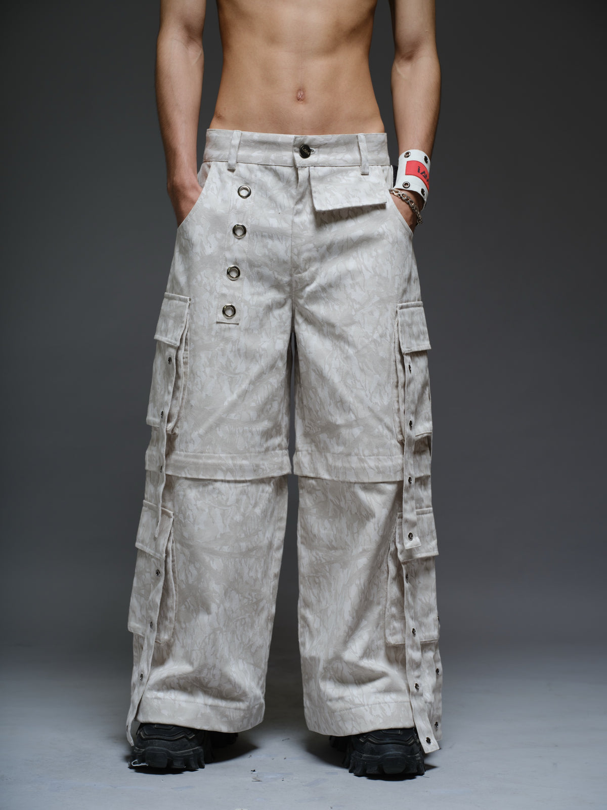Printed camo denim cargo pants with detachable lower legs, oversized flap pockets and hanging straps