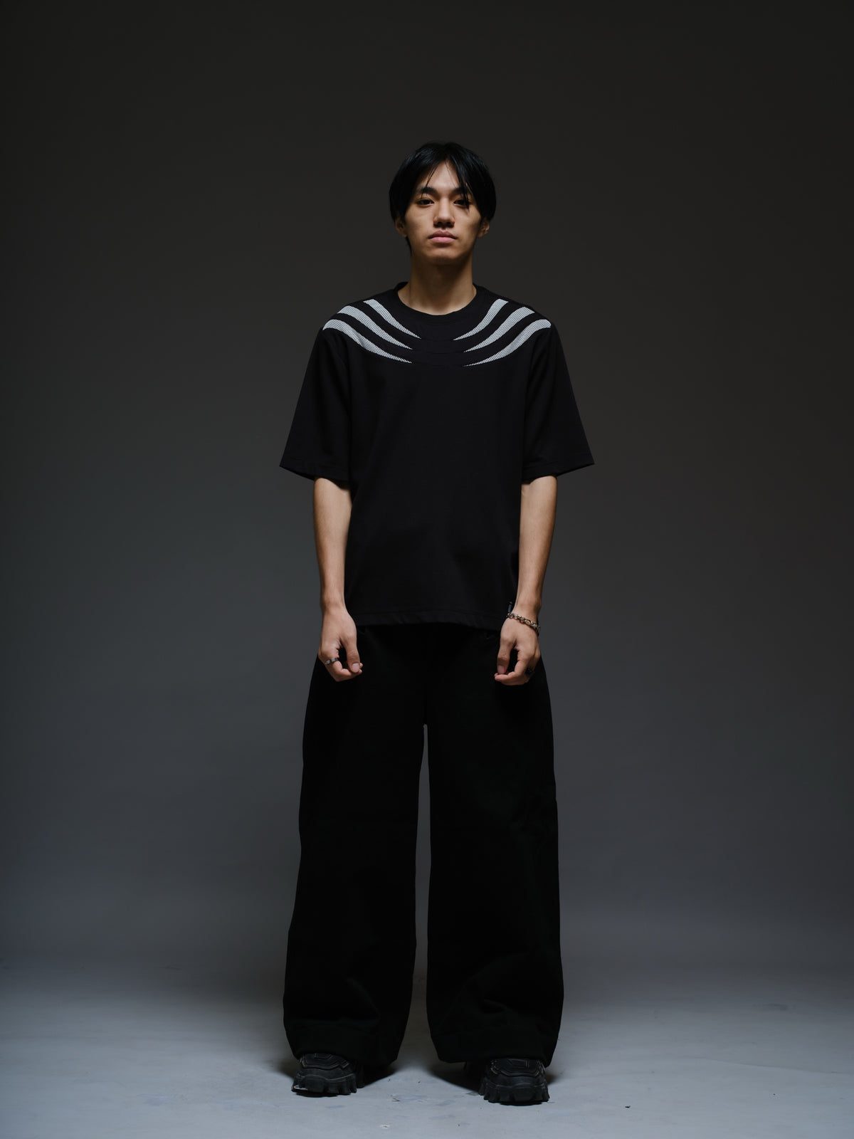 Relaxed black Roma knit tee with white net panels across the shoulders and upper chest