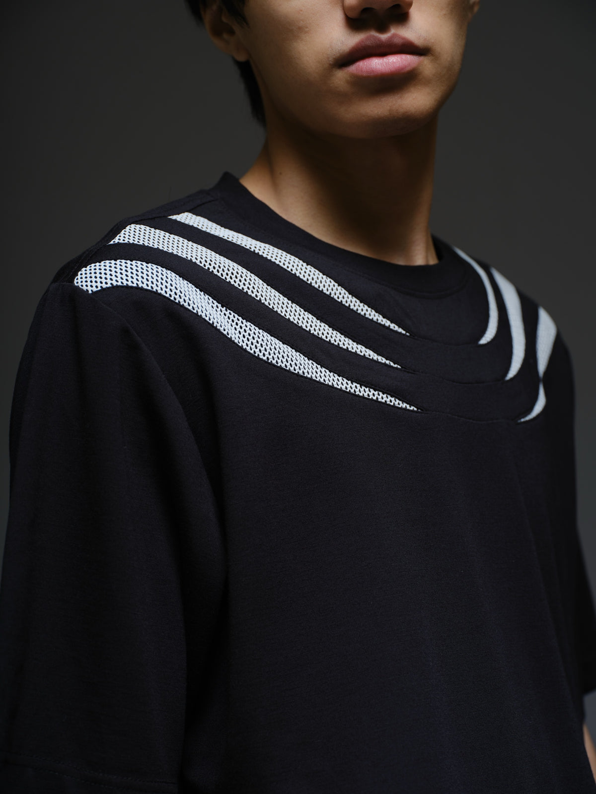Relaxed black Roma knit tee with white net panels across the shoulders and upper chest