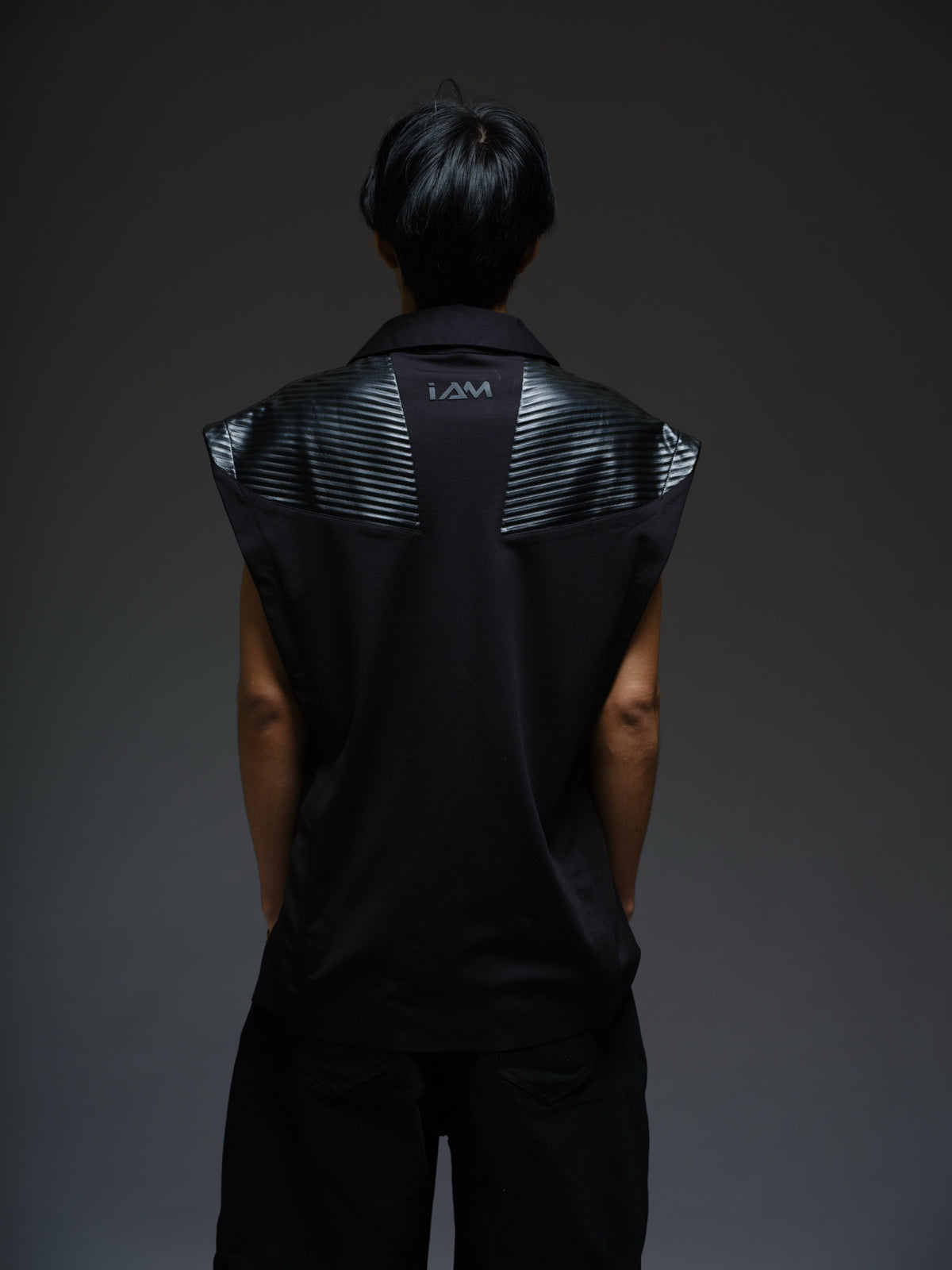 Onyx black sleeveless Roma knit tee with extended shoulders, stitched leather chest panels, a pointed collar and an open V neckline